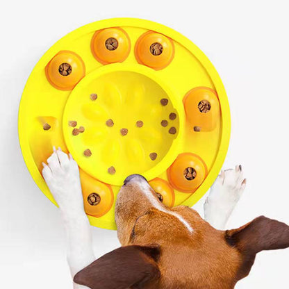 Dog interacting with a yellow puzzle toy filled with treats on a white background