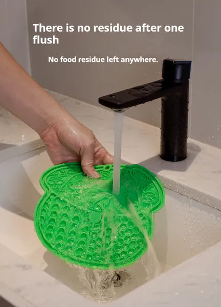 Green pet licking mat being rinsed under running water in a sink with text about no residue after one flush.